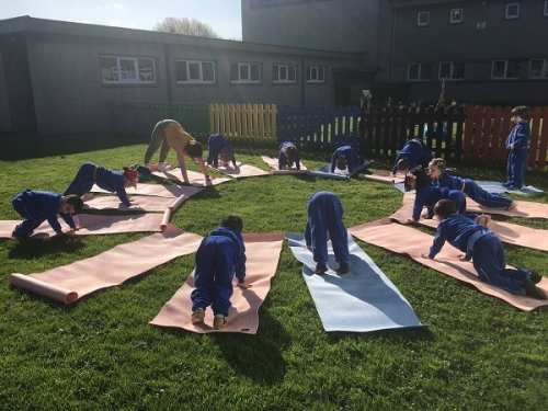 Early Start doing their Sun Salutation pose with Breda during Active Week